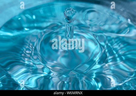 Texture di sfondo, con la caduta di gocce di acqua e onde con acqua blu Foto Stock