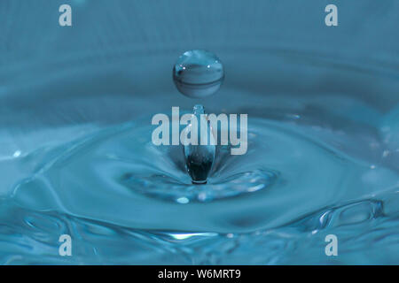 Texture di sfondo, con la caduta di gocce di acqua e onde con acqua blu Foto Stock