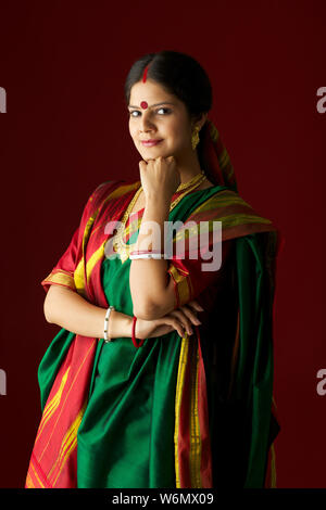 Bengali donna in piedi con la mano sul mento Foto Stock