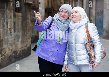 Felice donne anziane godendo di passeggiata in città durante il viaggio join Foto Stock