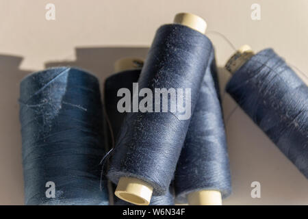 Una vista ravvicinata di cinque blu scuro di bobine di cotone in una pila su un sfondo isolato Foto Stock