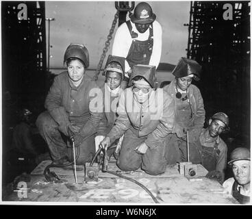 ... I saldatori Alivia Scott, Hattie Carpenter e Flossie Burtos attendono una possibilità di saldare il loro primo pezzo di acciaio sulla nave [SS George Washington Carver]., ca. 1943 Foto Stock
