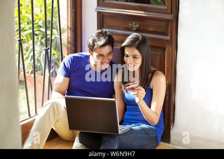 Coppia facendo shopping online con una carta di credito Foto Stock