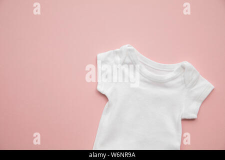 Carino baby corpo bianco tuta formato su un pastello sfondo rosa Foto Stock