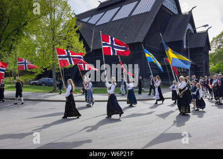 Patrioti norvegesi tenendo bandiere nazionali durante la annualmente Norways' Independence Day eventi vicino Skansen'ingresso del parco. La Scandinavia, Svezia Foto Stock