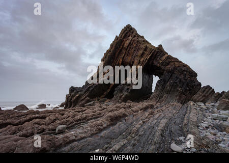 Blackchurch Rock è un punto di riferimento locale pietra naturale arco sulla North Devon costa. La marea è fuori così le rocce circostanti sono visibili. Foto Stock