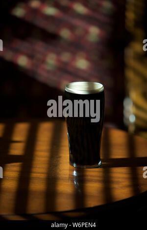 La pinta di Guinness su / bar pub tabella Foto Stock