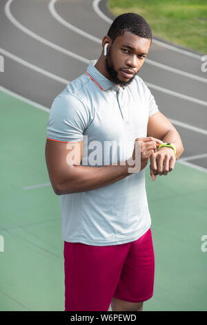 Atleta mantenendo la mano su un tracker di fitness Foto Stock