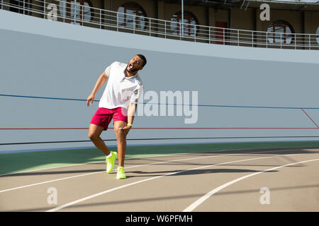 Muscolare maschio giovane runner che soffrono di lesioni rotula Foto Stock