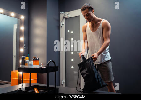 Nizza uomo bello tenendo fuori le sue scarpe Foto Stock