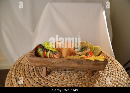 Cesto pieno di cibi che serve cibo con patatine fritte olive vegetariani vegan cetriolo calce fast food e alimenti insalubri cibi spazzatura bellezza del pane Foto Stock