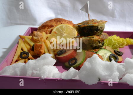 Cesto pieno di cibi che serve cibo con patatine fritte olive vegetariani vegan cetriolo calce fast food e alimenti insalubri cibi spazzatura bellezza del pane Foto Stock