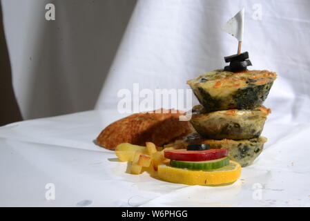 Cesto pieno di cibi che serve cibo con patatine fritte olive vegetariani vegan cetriolo calce fast food e alimenti insalubri cibi spazzatura bellezza del pane Foto Stock