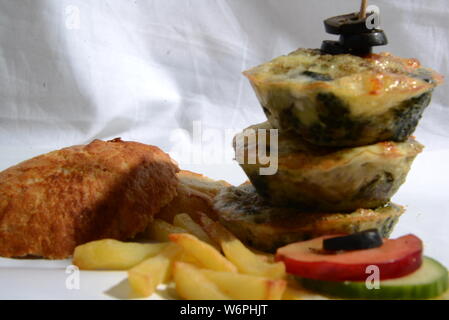 Cesto pieno di cibi che serve cibo con patatine fritte olive vegetariani vegan cetriolo calce fast food e alimenti insalubri cibi spazzatura bellezza del pane Foto Stock