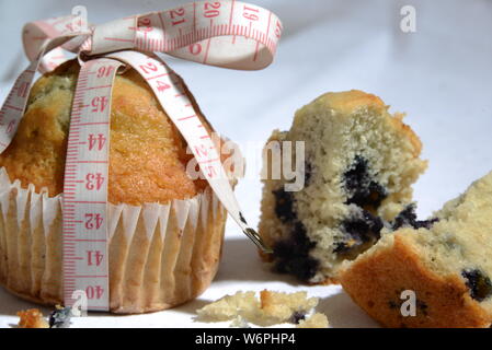 Cup cake e torte e perdere peso biscotto sta grasso e simbolo di dimensionamento del misuratore di peso la torta dal vicino foto significative junk food Foto Stock