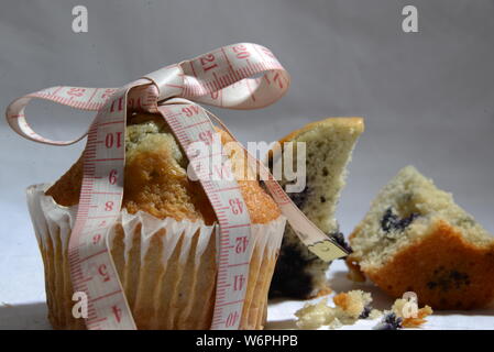 Cup cake e torte e perdere peso biscotto sta grasso e simbolo di dimensionamento del misuratore di peso la torta dal vicino foto significative junk food Foto Stock