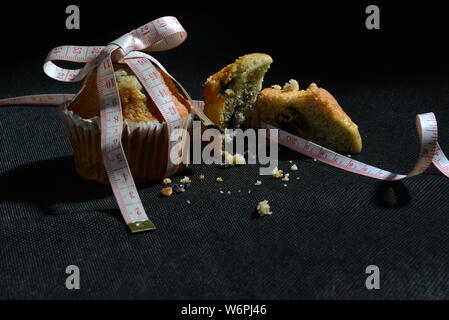 Cup cake e torte e perdere peso biscotto sta grasso e simbolo di dimensionamento del misuratore di peso la torta dal vicino foto significative junk food Foto Stock