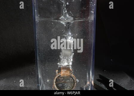 Foto professionali di accessori caduta in acqua al momento della depressione e bolle in acqua Foto Stock