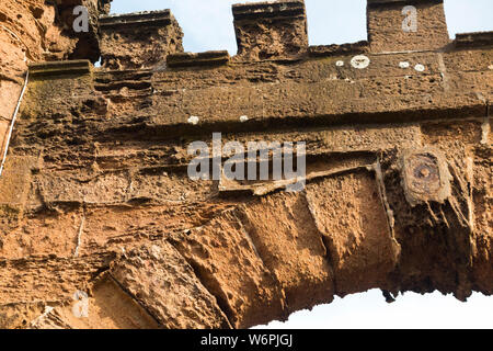 Casa del costruttore / muro mattone morbido utilizzato in una caratteristica castellated che è stato / è stato eroso da ghiaccio, tempo e gelo condizioni del Regno Unito. Il contrasto è chiaro tra il mattone morbido e i mattoni più duri sopra. (110) Foto Stock