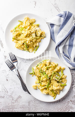 Uova strapazzate con freschi Asparagi verdi in una piastra bianca. La proteina sana prima colazione. Vista dall'alto. Foto Stock