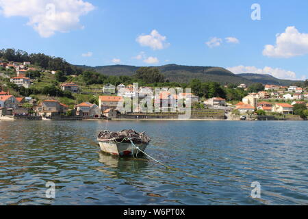 Vuota e solitaria sulla barca il mare di un bellissimo villaggio di pescatori in Galizia. Foto Stock