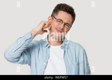 Studio headshot giovane uomo soffre di mal d'orecchi o rumore Foto Stock