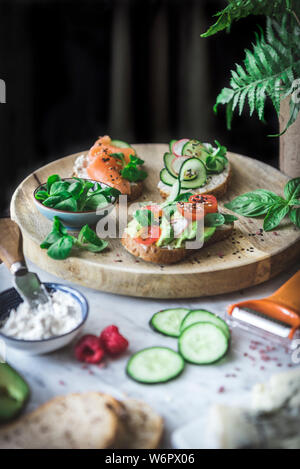 La bruschetta su un pane a bordo, lungo con vari ortaggi. Foto Stock