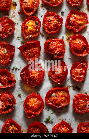 Arrosto di pomodori ciliegini, cosparsi di foglie di timo, sale marino e pepe nero pestato. Vista aerea. Foto Stock