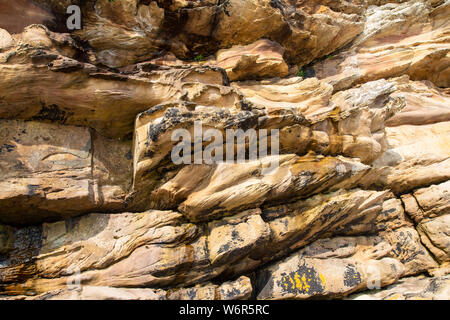 Guardando verso l'alto a scogliere rocciose nei pressi di Dunnett testa nel nord di Caithness in Scozia rivelando il vecchio di arenaria rossa e gli strati del Devoniano Superiore era Foto Stock