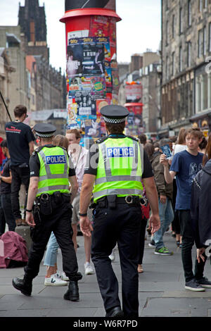 Il Royal Mile di Edimburgo, Scozia. Il 2 agosto 2019. Primo giorno di Edinburgh Fringe Festival e il Festival Internazionale e vi era molto evidente la presenza della polizia sulla Strada Alta, con alcuni ufficiali di pattuglia eventualmente per la rassicurazione per i residenti e i turisti. Foto Stock