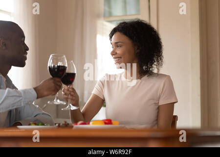 African sposi celebrare bicchieri tintinnanti tostare tenendo il vino rosso Foto Stock