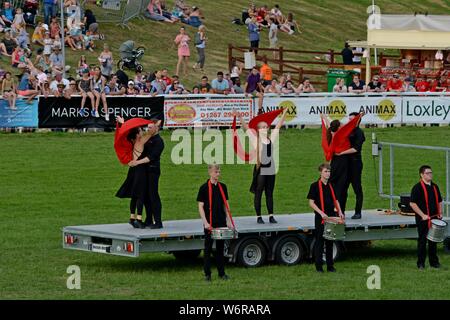 Gli artisti interpreti o esecutori e vintage machinery in un display e performance di danza per celebrare i 100 anni del Royal Welsh Show 2019, Builth Wells Foto Stock