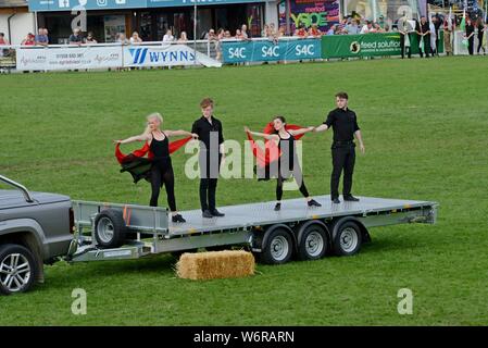 Gli artisti interpreti o esecutori e vintage machinery in un display e performance di danza per celebrare i 100 anni del Royal Welsh Show 2019, Builth Wells Foto Stock