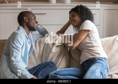 Coppia africana in amore seduti sul divano in chat si sente felice Foto Stock