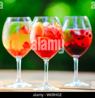 Summer cocktail. Cocktail di frutta su sfondo verde. Agrumi, frutti di bosco, fragole, mirtilli, menta, ghiaccio Foto Stock