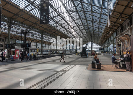 Treni a piattaforme a Tours in Francia storica stazione ferroviaria - Gare de Tours - costruito nel 1898. Il pianista utilizzando libero di utilizzare il piano sulla destra, con il pubblico. Foto Stock