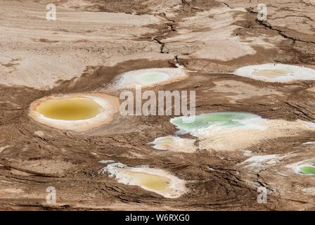 Dolina causato dalla recessione a livello acqua del Mar Morto, Israele. Un acqua calda primavera riempie il foro. Foto Stock