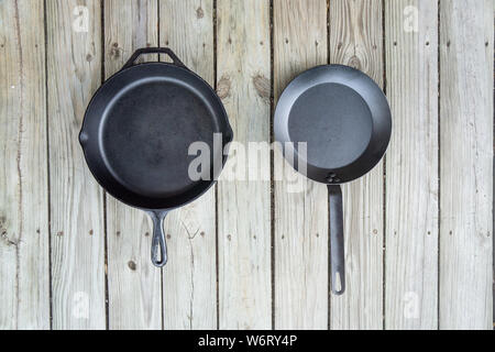 Tradizionale ghisa vs acciaio al carbonio versus teflon opzioni di cottura - vuota stanza vuota per il testo o per copiare lo spazio. Due pentole pezzi - fornello da cucina per Foto Stock