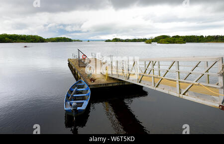 Lone barca legato al piccolo molo sul Lough Leane, il più grande e il più settentrionale dei tre laghi di Killarney National Park, nella contea di Kerry, Irlanda Foto Stock