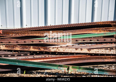 Palo di pali di recinzione in acciaio arrugginito sul terreno Foto Stock