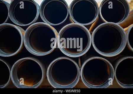 Tubi in acciaio mazzetto sul rack in magazzino. Tubi di ferro a mensola in magazzino. Foto Stock