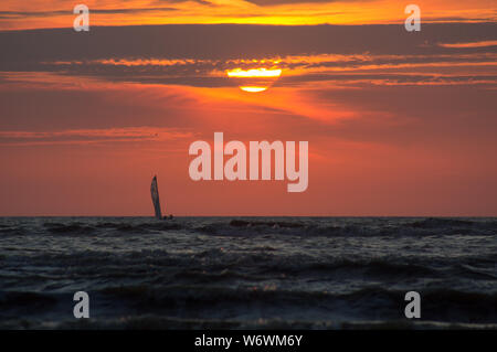 Silhouette di una barca a vela al tramonto del tempo. Foto Stock