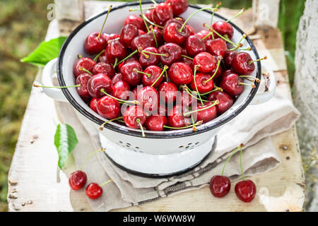 Fresco e ciliegie dolci sul bianco vecchia succhieruola Foto Stock