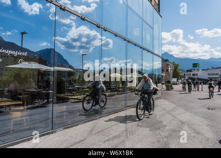 Finestra riflessioni di gente che si diverte durante una soleggiata giornata estiva nella città di Innsbruck campidoglio provinciale città del Tirolo in Austria Foto Stock