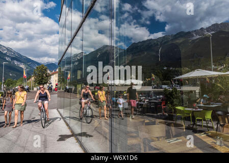 Finestra riflessioni di gente che si diverte durante una soleggiata giornata estiva nella città di Innsbruck campidoglio provinciale città del Tirolo in Austria Foto Stock