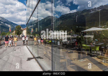 Finestra riflessioni di gente che si diverte durante una soleggiata giornata estiva nella città di Innsbruck campidoglio provinciale città del Tirolo in Austria Foto Stock