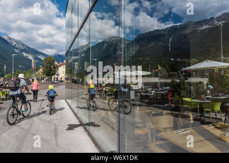 Finestra riflessioni di gente che si diverte durante una soleggiata giornata estiva nella città di Innsbruck campidoglio provinciale città del Tirolo in Austria Foto Stock