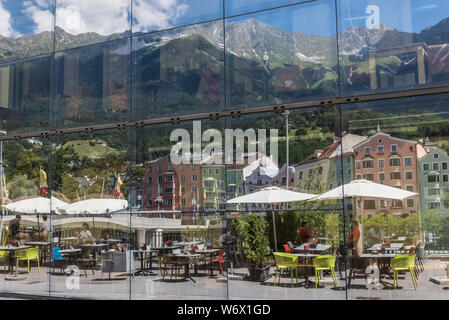 Finestra riflessioni di gente che si diverte durante una soleggiata giornata estiva nella città di Innsbruck campidoglio provinciale città del Tirolo in Austria Foto Stock