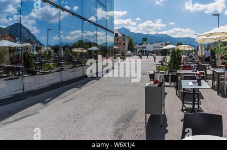 Finestra riflessioni di gente che si diverte durante una soleggiata giornata estiva nella città di Innsbruck campidoglio provinciale città del Tirolo in Austria Foto Stock