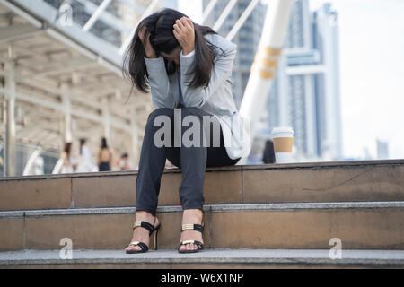 Imprenditrice disperata sulla linea preoccupato dopo aver disoccupati presso la scala con le sue mani nella testa. Foto Stock
